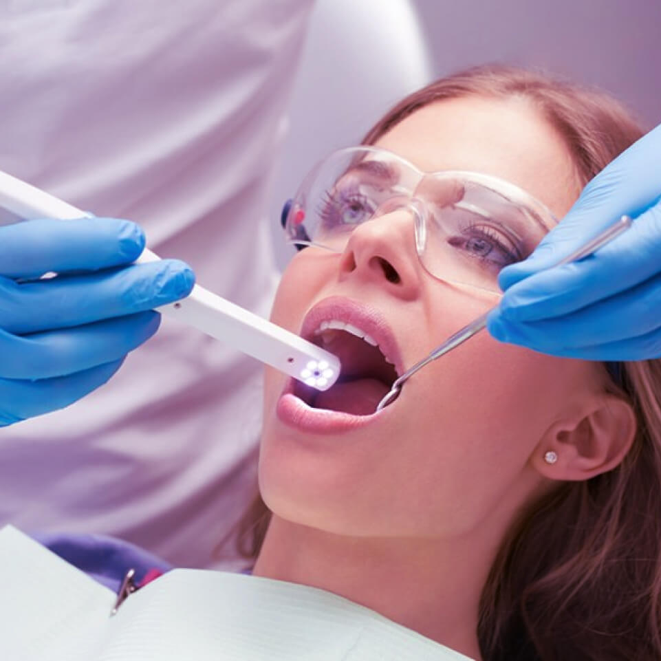 Câmera intraoral. Paciente sendo escaenada por uma câmera intraoral.