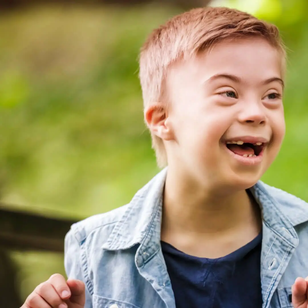 Retrato de um menino com síndrome de down enquanto brinca em um parque