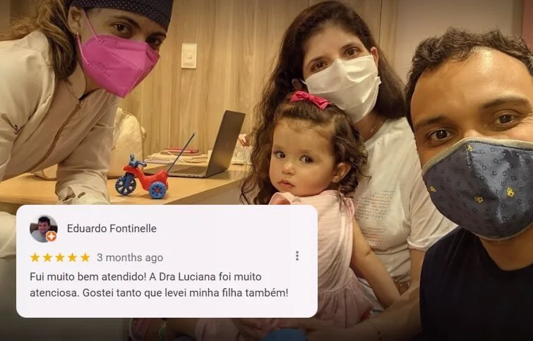 Foto de pacientes da Clínica Aurora, sendo um casal, homem e mulher, segurando a filha bebê. Estão sorridentes ao lado da Dra.