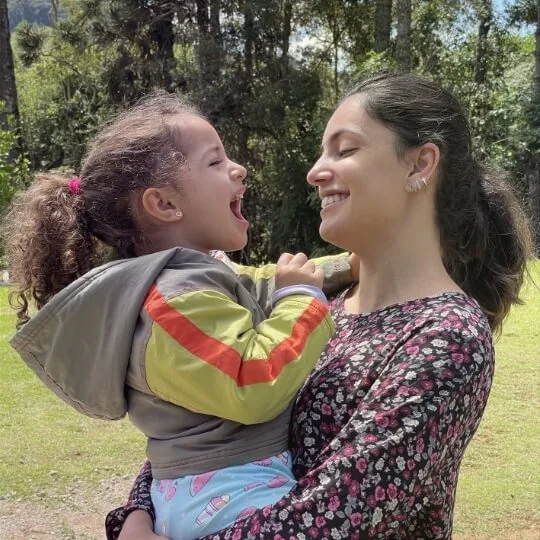 Odontopediatra em Ouro Preto: Dra Luciana com uma criança no colo.